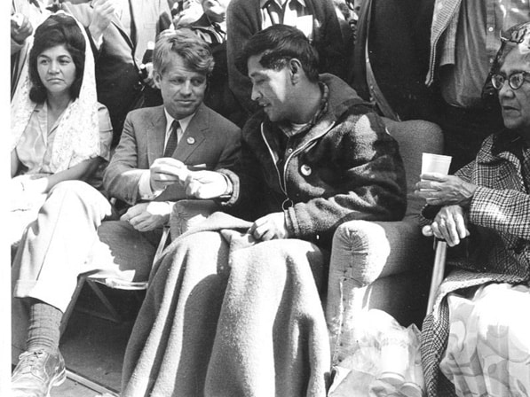 Robert F. Kennedy (middle) offers César Chávez (right) bread in a symbol of support at the end of Chávez’s 1968 hunger strike for farm workers in Delano, CA.