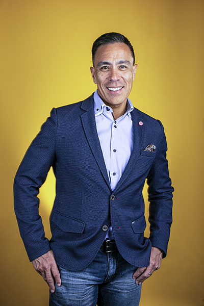Guillermo Diaz, SVP of Customer Transformation, Cisco Systems, portrait yellow background