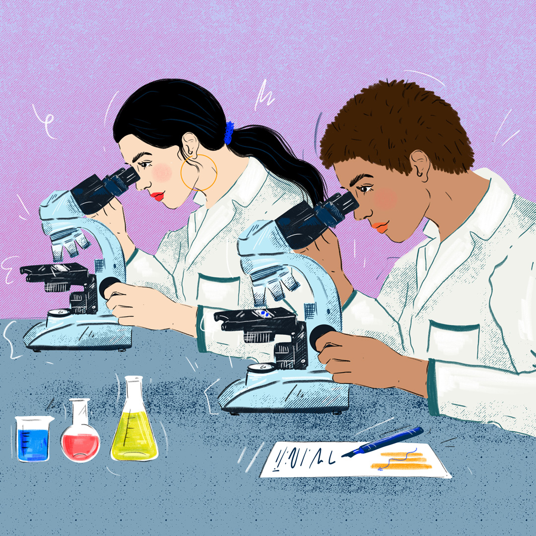 Two women scientists of color look into their respective microscopes to study material. They are both wearing lab coats and surrounded by various solutions and a document with their notes on it.