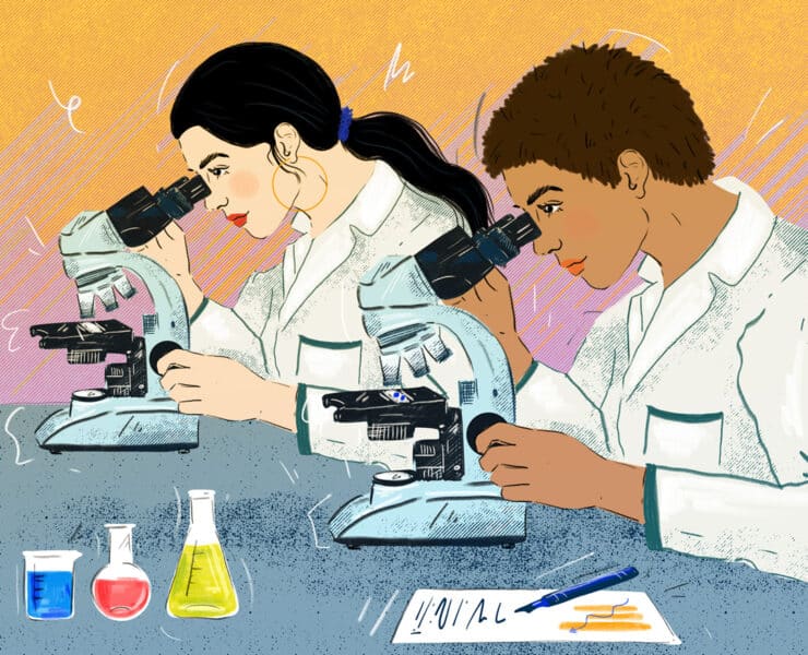 Two women scientists of color look into their respective microscopes to study material. They are both wearing lab coats and surrounded by various solutions and a document with their notes on it.