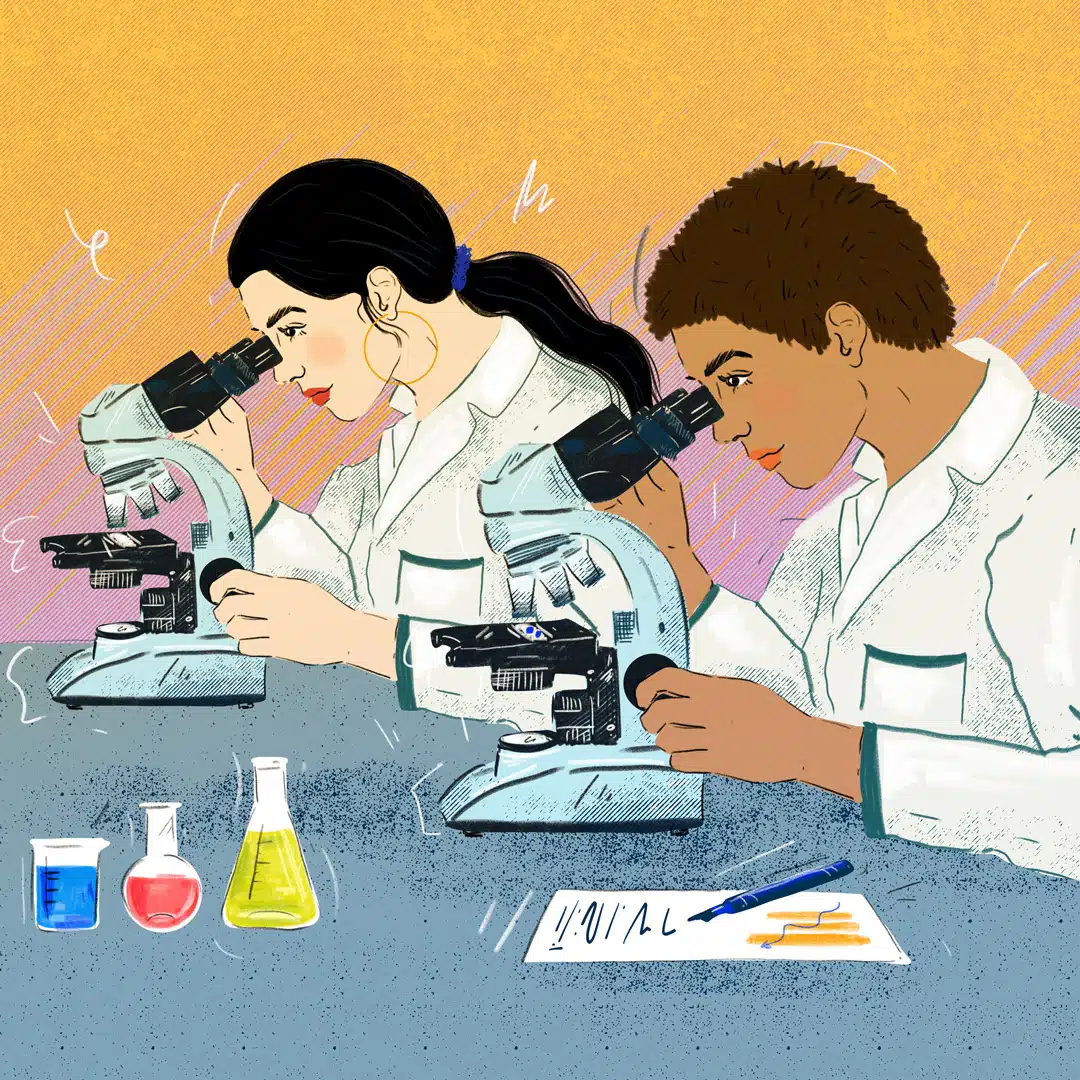 Two women scientists of color look into their respective microscopes to study material. They are both wearing lab coats and surrounded by various solutions and a document with their notes on it.