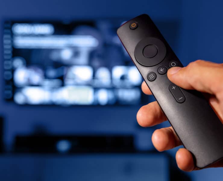 A person is holding a SmartTV remote while on Netflix