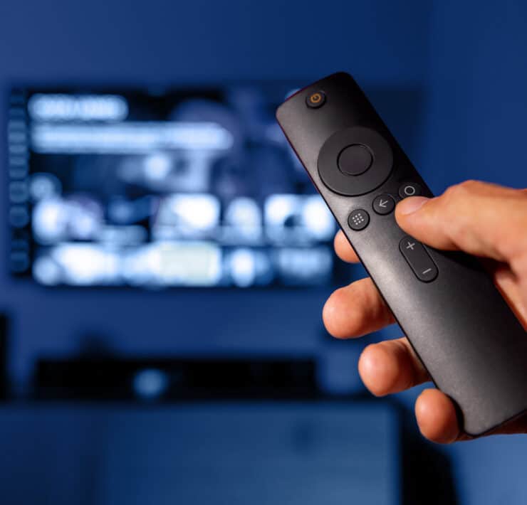 A person is holding a SmartTV remote while on Netflix