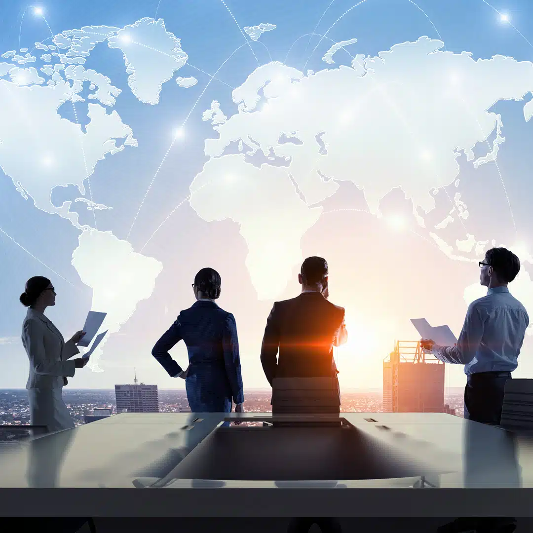 Two men and two women stand facing away from the viewer, looking out over a city with the global map transparent above them in the background