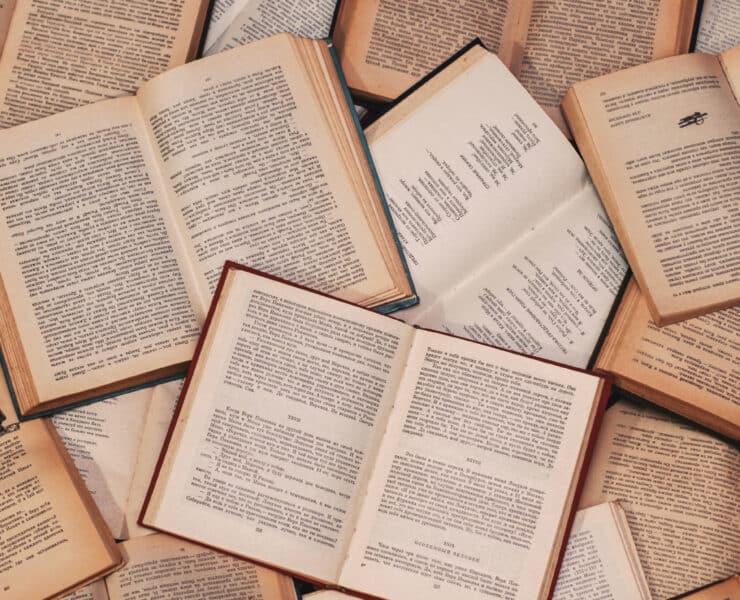 A collection of books open and laid out with their written words exposed
