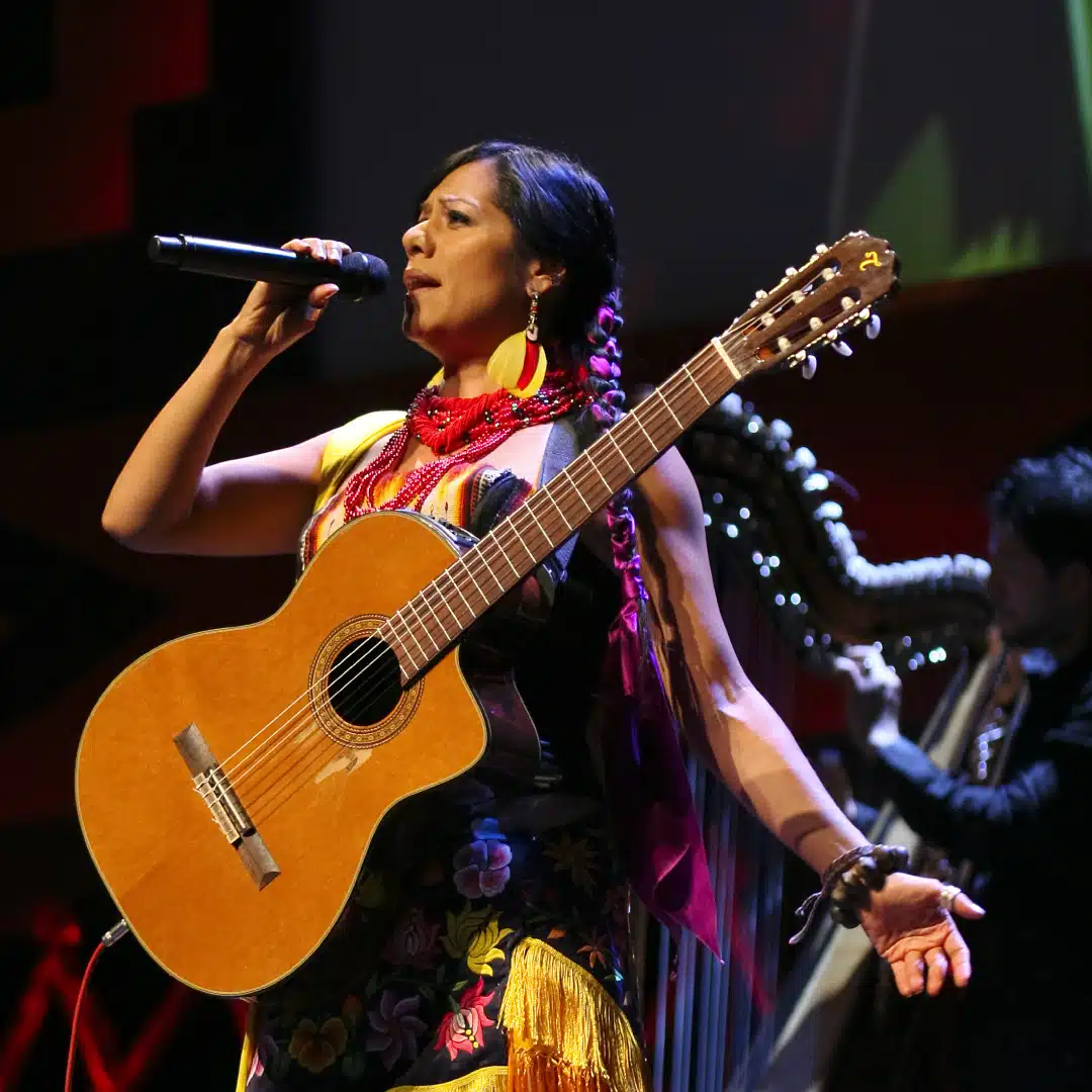 Mexican American singer-songwriter and activist Lila Downs sings with a guitar strapped to her chest