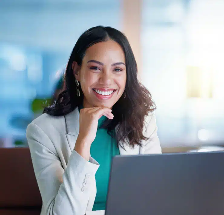 Woman smiling behind laptop