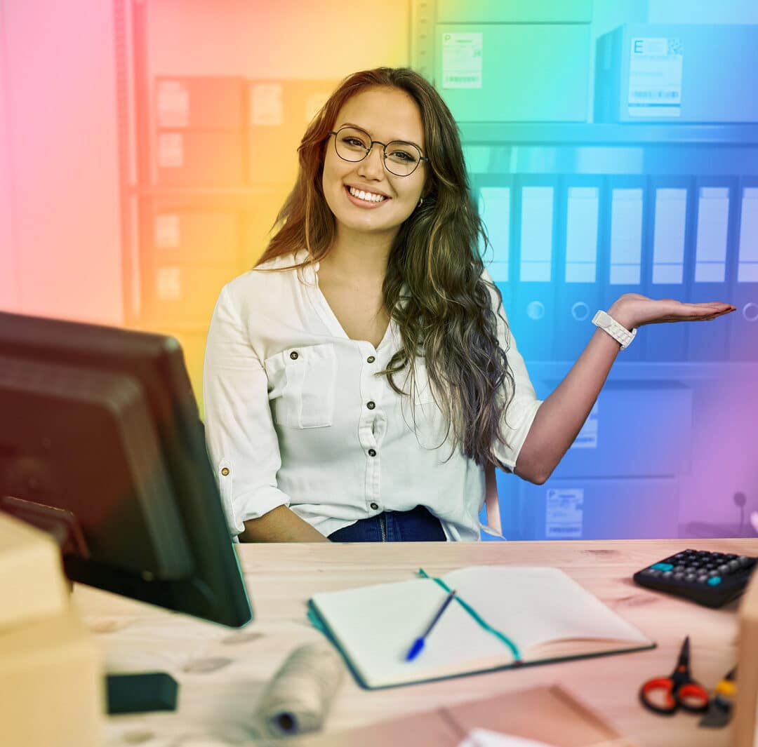 LGBTQ+ Lation-Owned Businesses image of woman sitting behind her desk with rainbow filter